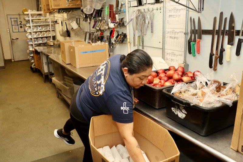 Anna Babez packs up the snack bags that might contain fruit, pudding or cereal.